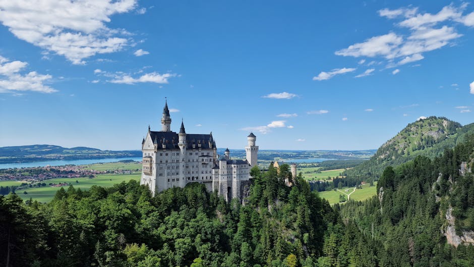 Stunning aerial view of Neuschwanstein Castle in Bavaria, Germany, surrounded by lush greenery.
